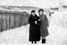 308: Mollie McCarthy and her grandmother Mrs. Stasia Dunphy, with the church and old school in the  background. Leo Whalen's garden fence is on the left; Thomas Rose's house is in the background. (1940)  - Mollie daughter of James McCarthy &amp;amp; Julia Reddy; Mrs. Stasia the wife of Patrick Dunphy &amp;amp; the widow of Thomas McCarthy